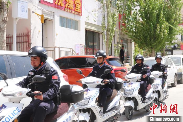 民警騎著電瓶車在轄區(qū)巡邏走訪。　黃創(chuàng)偉 攝