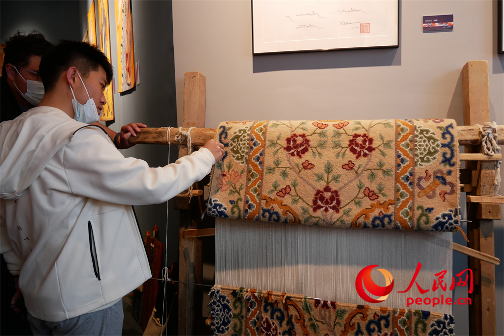 觀眾正在觀賞展出的藏毯。人民網(wǎng) 韋衍行攝