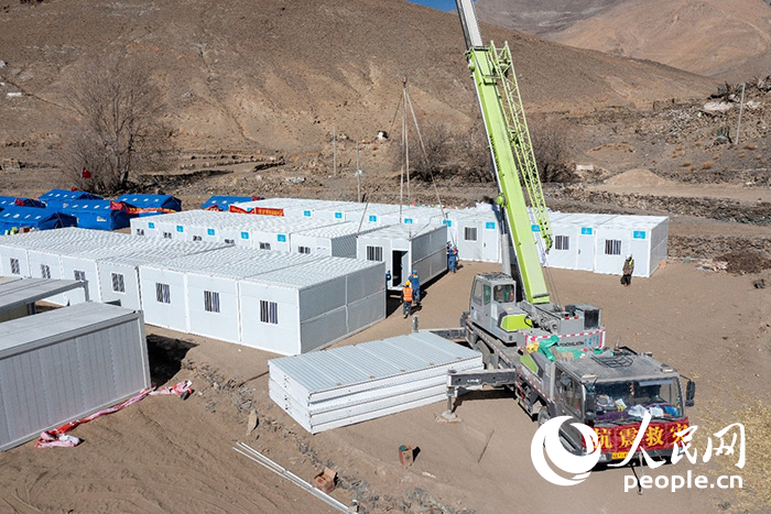 1月9日，在日喀則市定日縣長(zhǎng)所鄉(xiāng)古榮村安置點(diǎn)，救援人員和施工人員合力抓緊搭建移動(dòng)板房，確保受災(zāi)群眾溫暖過冬。人民網(wǎng)記者 翁奇羽攝