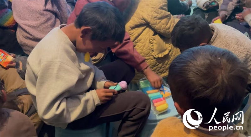 措果鄉(xiāng)塘仁村的孩子們正在用橡皮泥制作自己的情緒“小怪獸”。人民網(wǎng)記者 郝潔攝