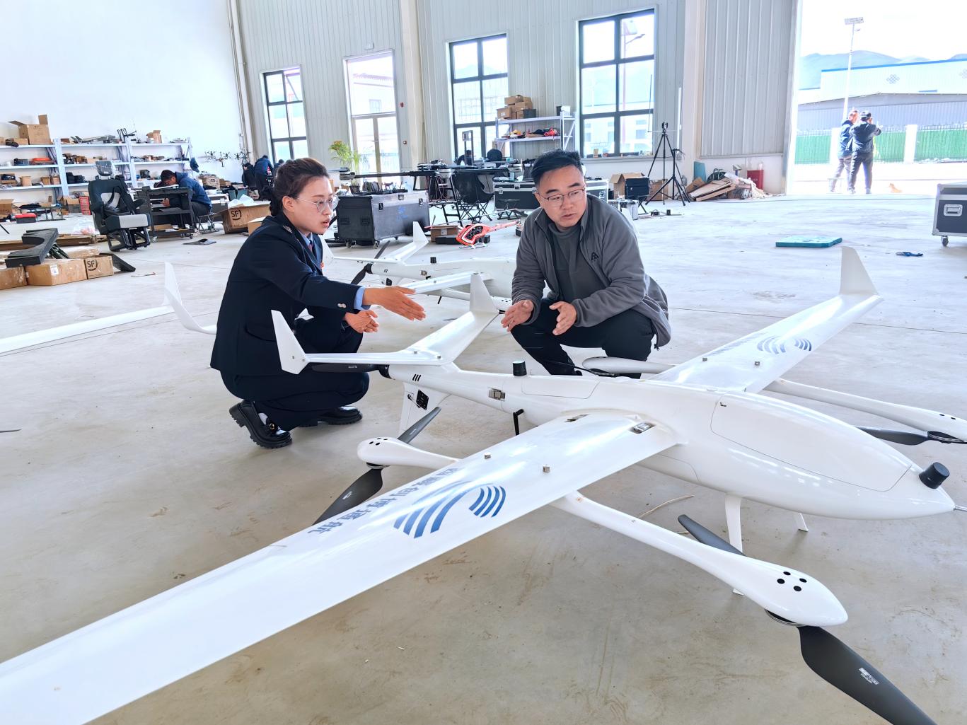 創(chuàng)博通航工作人員向稅務(wù)干部介紹無人機(jī)情況。曲麗攝