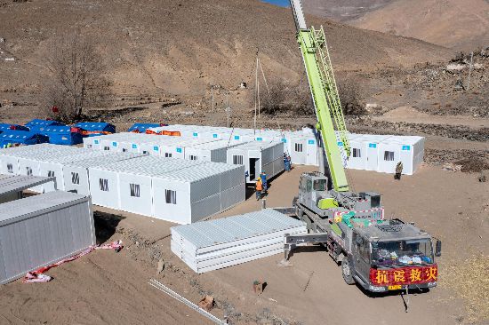 2025年1月9日，在定日縣長所鄉(xiāng)古榮村安置點(diǎn)，救援人員和施工人員合力抓緊搭建移動(dòng)板房，確保受災(zāi)群眾溫暖過冬。人民網(wǎng)記者 翁奇羽攝