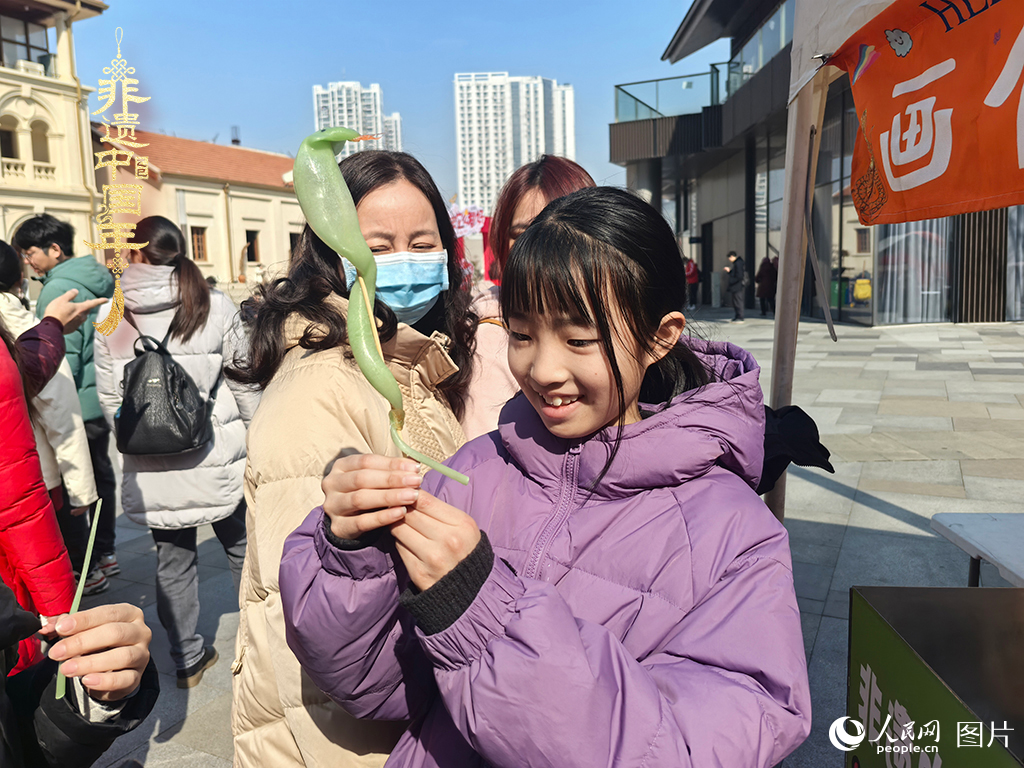 2025年1月29日，湖北武漢的新春廟會上，小朋友拿著吹制好的糖人，十分開心。人民網(wǎng)記者 張沛攝