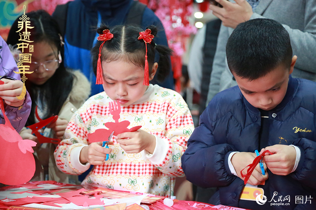 2025年1月23日，上海市青少年活動中心迎新春游園會上，小朋友們正在學習剪窗花。人民網(wǎng)記者 龔莎攝