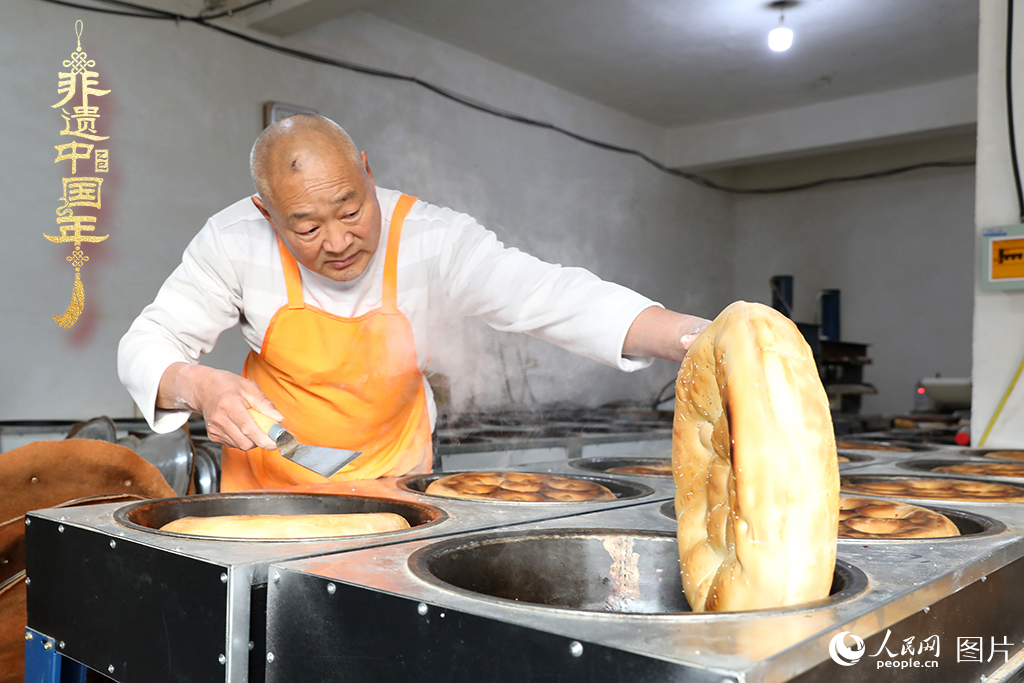 2025年1月23日，山東省臨沂市莒南縣一家傳統(tǒng)大餅作坊內，師傅們正忙著烤制當?shù)厝舜汗?jié)期間家家戶戶必備的、金黃誘人的莒南大餅。人民網(wǎng)記者 劉祺攝