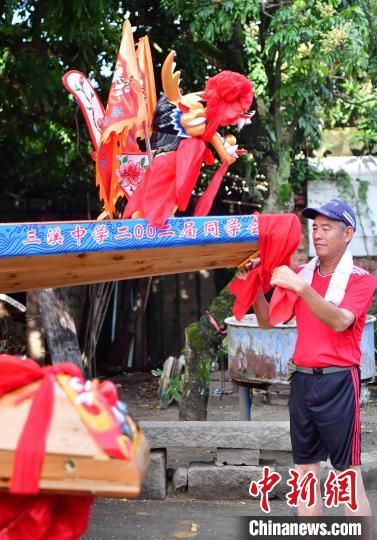圖為5月29日，長(zhǎng)樂(lè)江田鎮(zhèn)村民為即將入水的新龍舟系紅布?！埍?攝