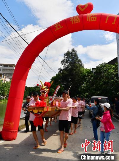 圖為5月29日，長(zhǎng)樂(lè)江田鎮(zhèn)村民們推著新龍舟前行?！埍?攝