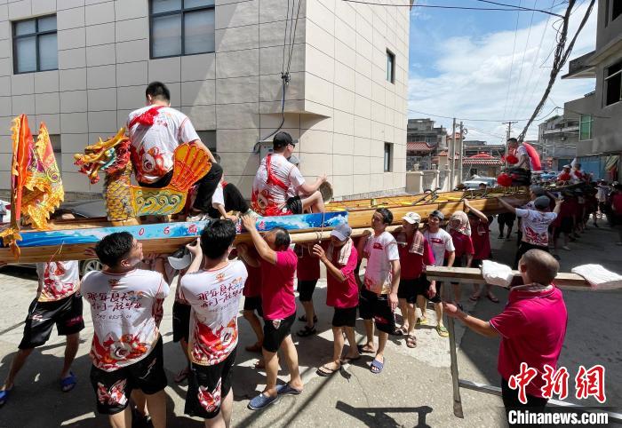 圖為5月29日，長(zhǎng)樂(lè)江田鎮(zhèn)村民們肩扛著新龍舟舉行入水前游街儀式?！埍?攝