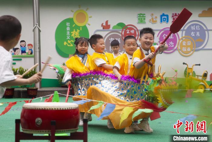 圖為龍舟賽游戲上，小伙伴們打鼓加油?！《^生 攝
