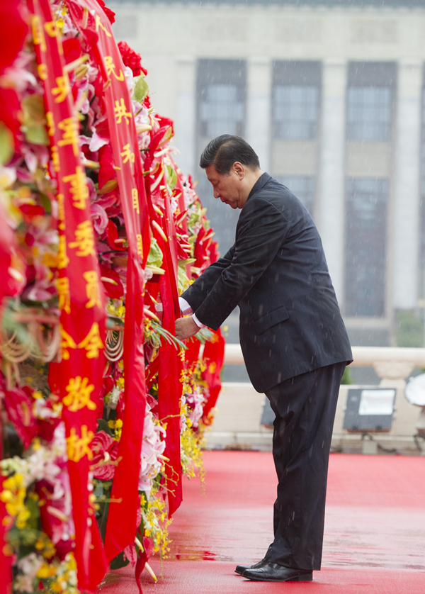 2013年10月1日上午，在首都各界代表向人民英雄紀(jì)念碑敬獻(xiàn)花籃儀式上，習(xí)近平整理花籃上的緞帶。